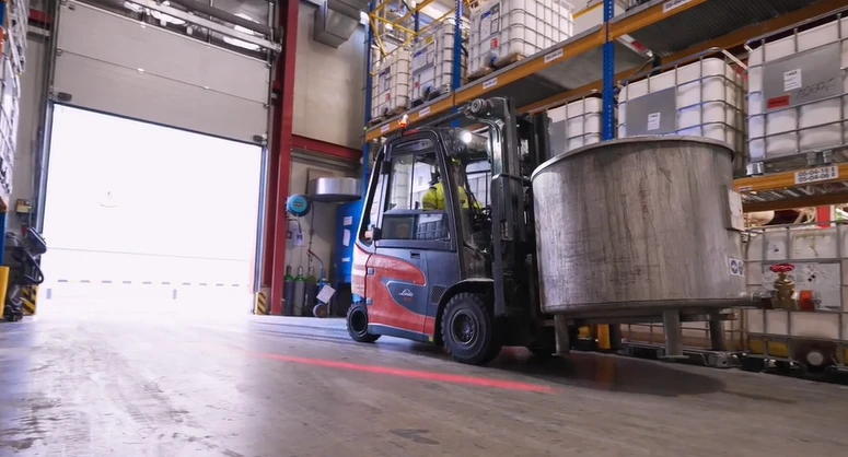 ATEX certified forklift moving stainless chemical container at loading bay ATEX certified forklift moving stainless chemical container at loading bay