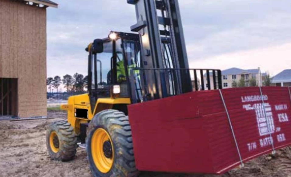 Off-road forklift carrying construction panels on dirt building site Off-road forklift carrying construction panels on dirt building site