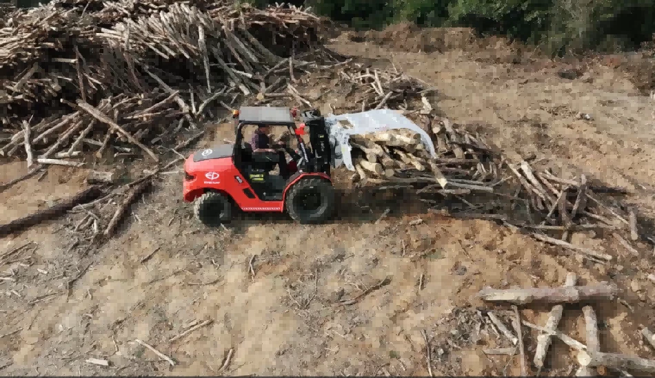 Off-road forklift with log grab attachment working in lumber yard1 Off-road forklift with log grab attachment working in lumber yard1