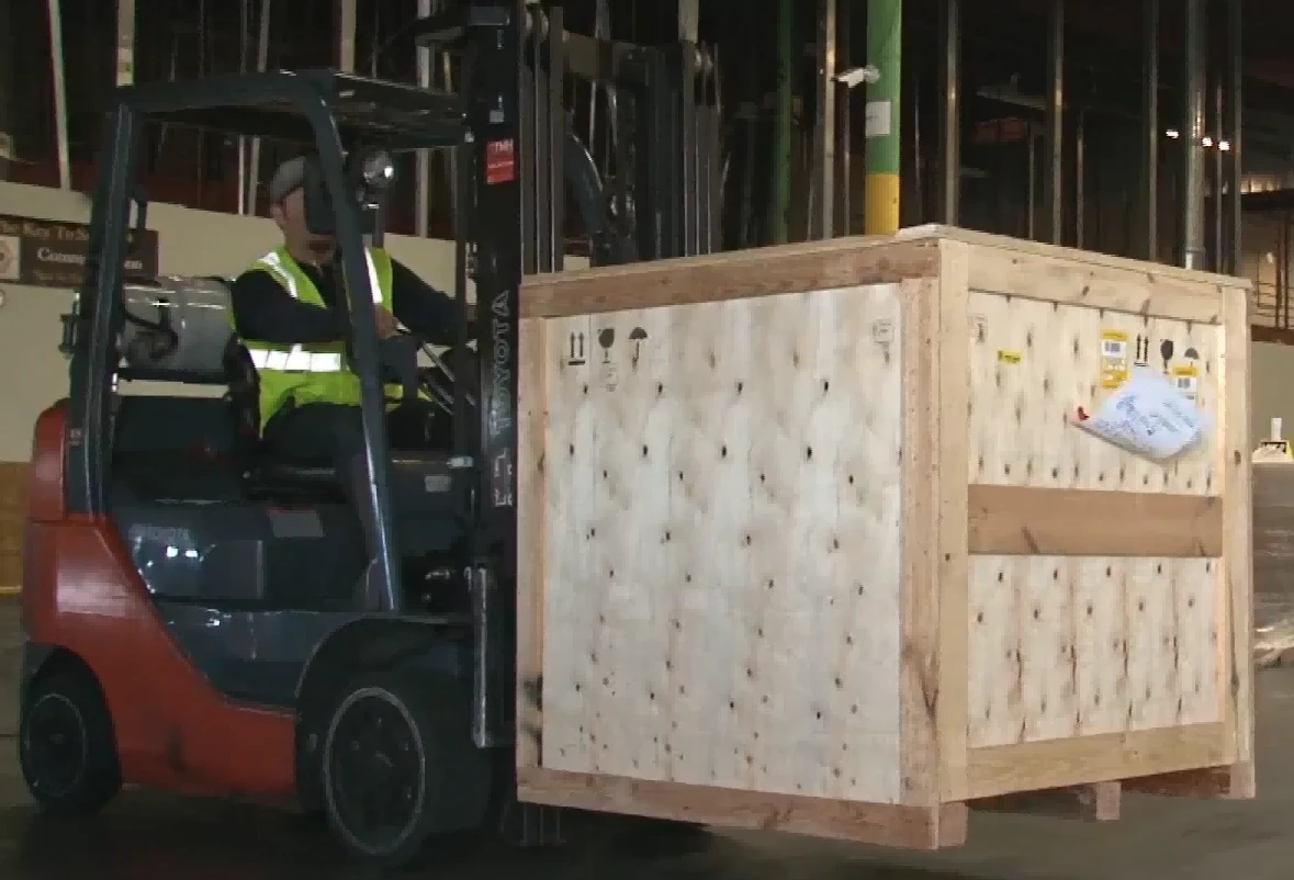Counterbalance forklift lifting large offcenter wooden crate1 Counterbalance forklift lifting large offcenter wooden crate1